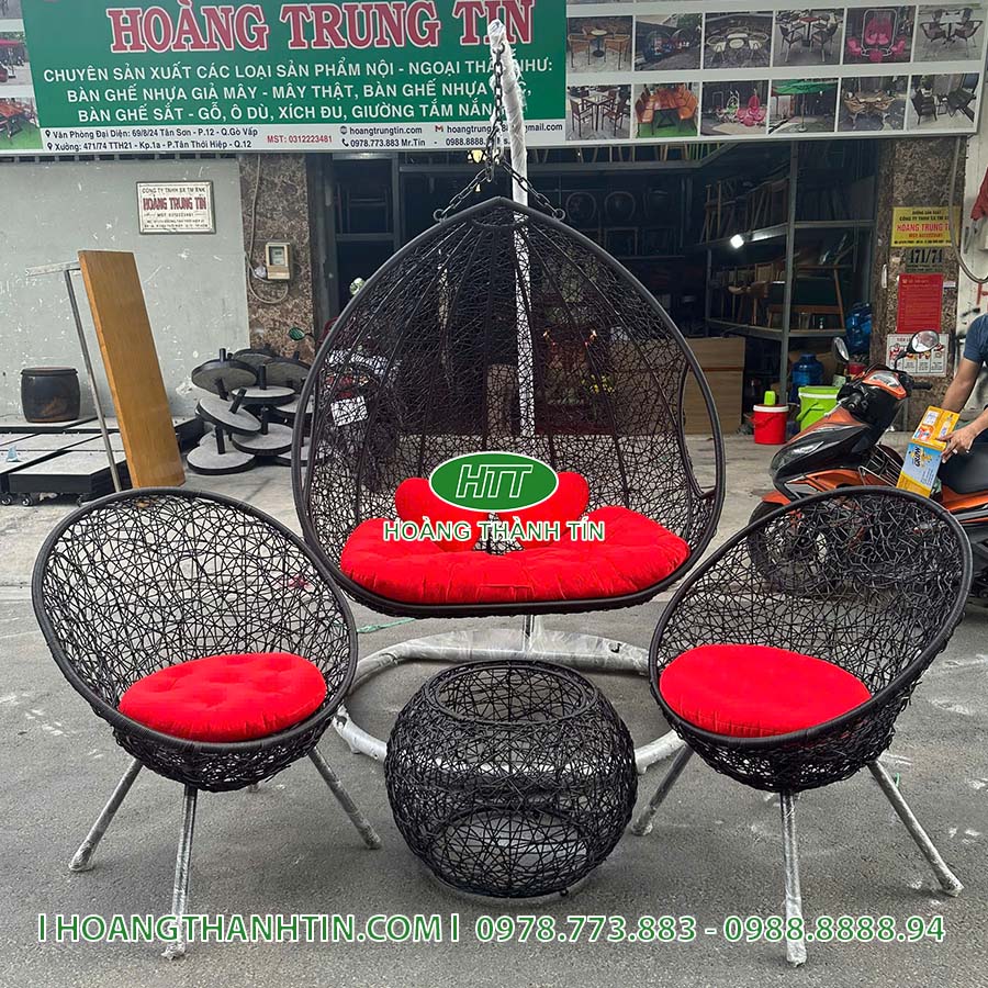 Bộ xích đu bàn ghế HTT 9 nhìn tổng thể - hai ghế nệm đỏ hai bên, bàn đan tròn ở giữa, xích đu treo phía sau
