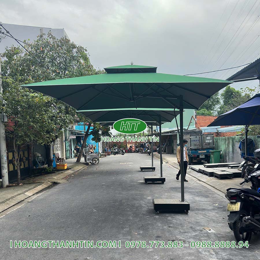 D&ugrave; che nắng vu&ocirc;ng m&agrave;u xanh r&ecirc;u đậm với đế đ&aacute; nguy&ecirc;n khối k&ecirc; ngo&agrave;i đường